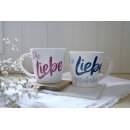 Eine Tassen mit pinker Schrift die andere ist mit Blauer Schrift versehen